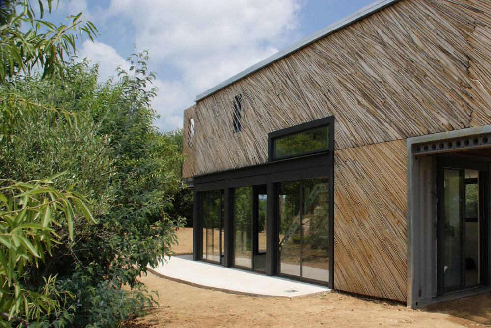 una-casa-container-pintada-de-color-blanco-con-revestimiento-de-madera-en-la-fachada